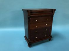 A miniature mahogany Victorian straight front chest of drawers, with cushion drawer, below four long