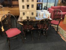 An oak drawer leaf table and six windsor chairs