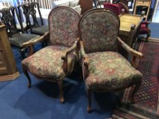 A pair of walnut framed elbow chairs