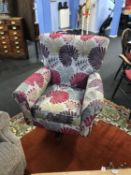 A large floral upholstered swivel armchair