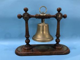 A dinner bell, on an oak stand