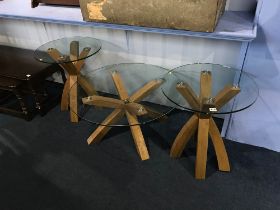 A set of three glass top tables