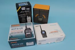 A boxed Maas AHT-6-UV handheld, a Baofeng UV-5R plus, a Wouxun KG-D901 and an Anytone AT - D878