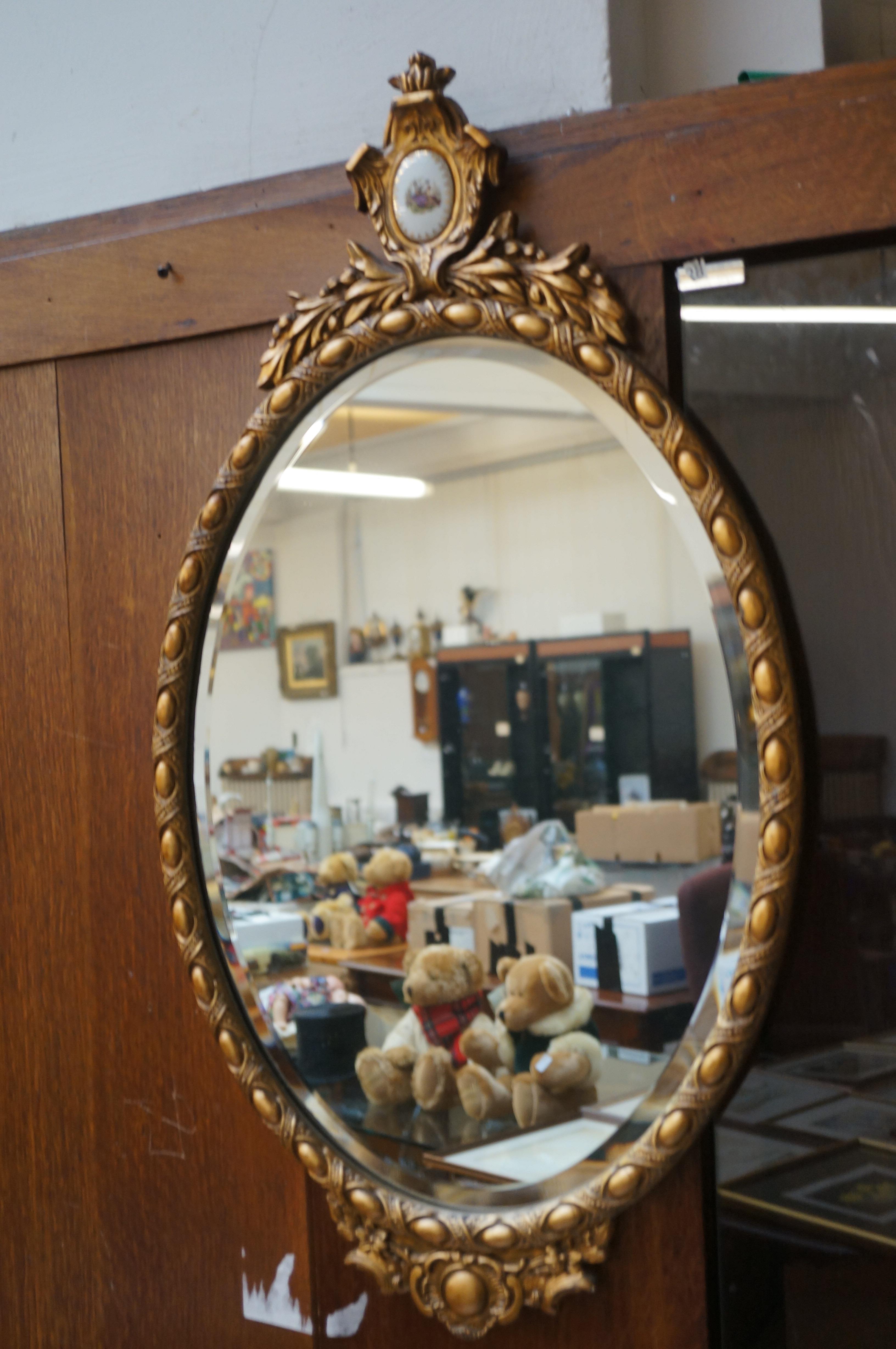 Oval gilt mirror with ceramic plaque