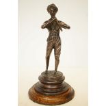 Bronze figure of a boy playing a flute on wooden b