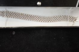 Silver bracelet set with white stones