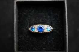 Gold on silver ring set with light blue & white stones