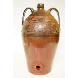 A large and heavy terracotta wine or oil dispenser