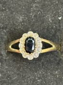 9ct gold ring set with central sapphire surrounded