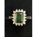 Platinum ring set with large emerald surrounded by