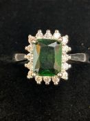Platinum ring set with large emerald surrounded by