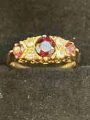 9ct Gold ring set with 3 garnets & 4 white stones