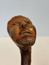 Carved face handle walking stick