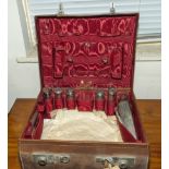 A gentleman's travelling case with silver topped bottles and brush, incomplete