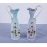 A pair of Victorian decorated satin glass ewers 25cm tall