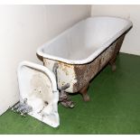 A vintage cast iron roll top bath together with a wash basin, unusual tap design