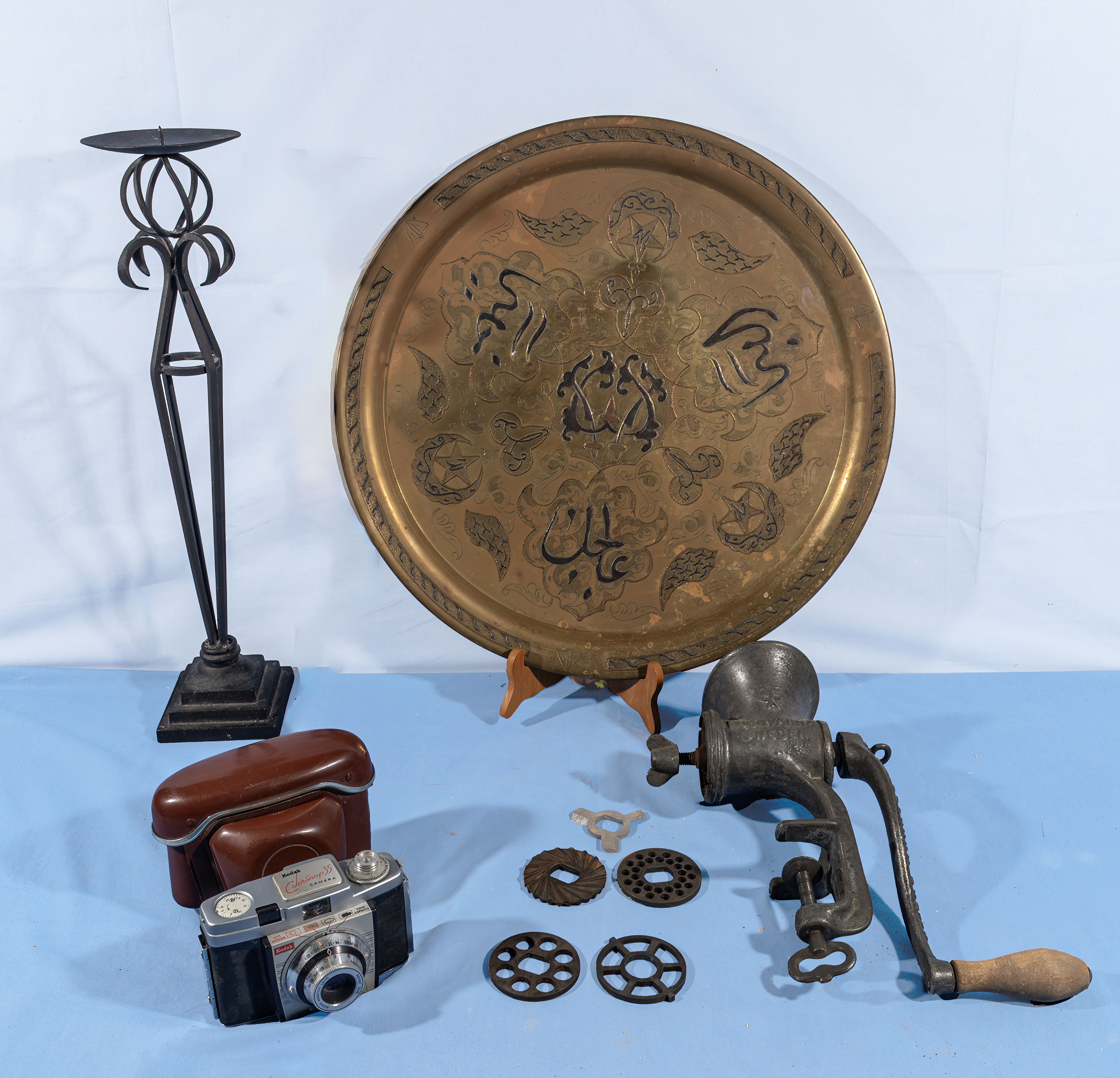 A brass tray, candle stand, vintage mincer and a camera