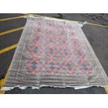 A hand woven Asian red and grey ground rug having floral motifs and tasselled ends, 344cm x 261cm