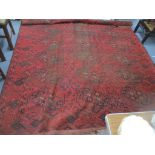 A Persian hand-woven red ground rug decorated with elephant gulls and geometric floral devices,
