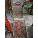 A group of three Persian style rugs to include a red ground rug with central floral motif, triple
