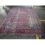 A Persian rug with angular flora and foliage, on a red ground (worn) 365cm x 262cm Location: