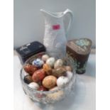 A collection of decorative eggs in onyx, wood and china together with two vintage tins and a white