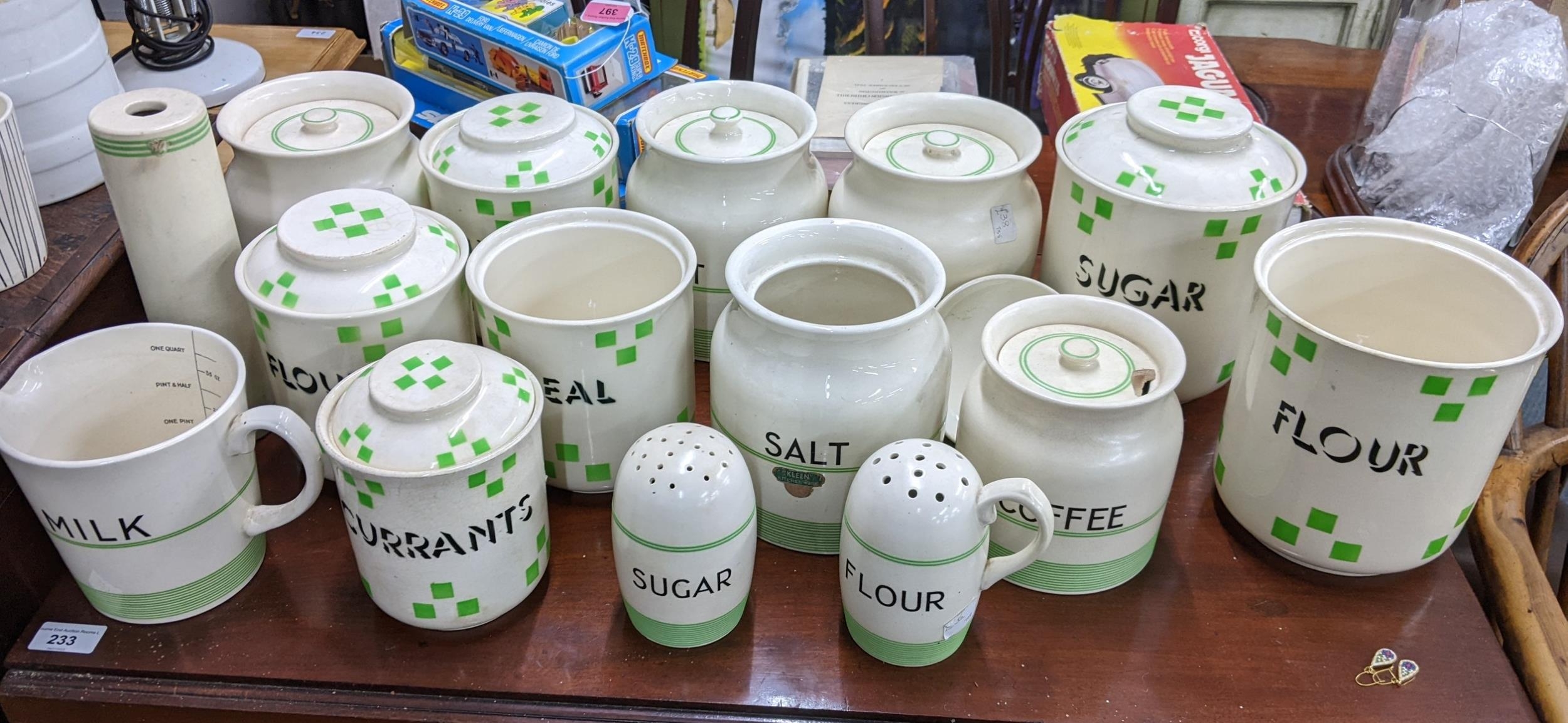 A quantity of early 20th century kitchen storage jars, some with lids having a cream glaze with