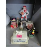 A group of ceramic advertising figures and character jugs to include a Carlton ware Pick Flowers
