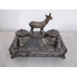 A late 19th/early 20th century silver plated inkstand mounted with a deer to the top Location: