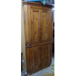 A Georgian pine corner cabinet having a moulded cornice above four panelled doors, 218cm h x 96cm