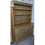 A Victorian pine dresser having a plate rack above two short and two panelled doors, 217cm h x 142.