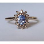 A 9ct gold and pale blue stone with 12 diamond surround dress ring, makers initials DOM, total