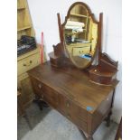 An Edwardian mahogany dressing table with shield shaped swing mirror flanked by glove drawers,