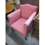 An Edwardian mahogany armchair upholstered in a pink coloured fabric on square tapering legs, and