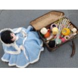 A small knitted case with needles and reels together with a 1970's bed dolly in knitted outfit