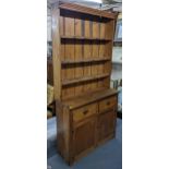 A Victorian pine narrow dresser having a plate rack above two drawers and two cupboards, 219cm h x