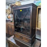 A George III mahogany cabinet on cabinet, the upper part with a glazed door, over a drawer, on