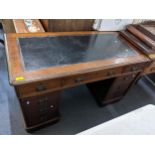 A late 19th/early 20th century mahogany twin pedestal leather topped desk having one long and