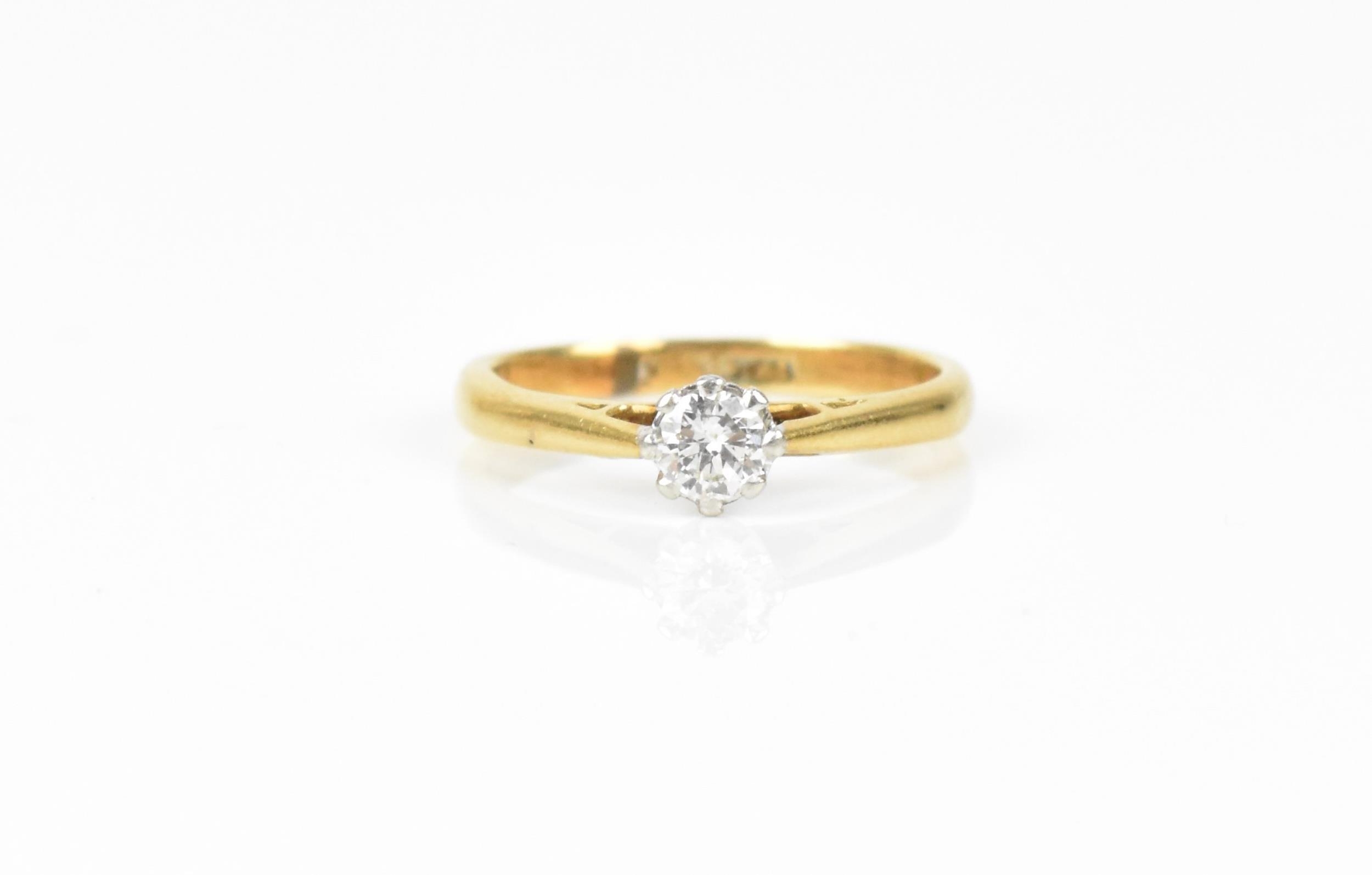 An 18ct yellow gold, platinum and diamond solitaire ring, the brilliant cut stone set in an eight