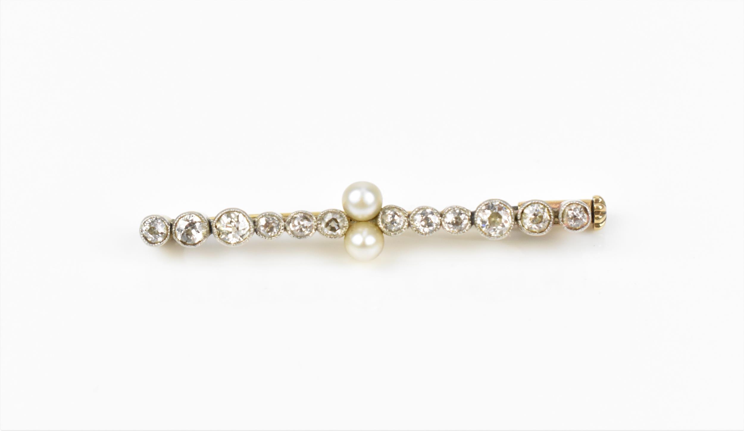 A yellow and white metal, diamond and pearl bar brooch, designed with twelve various sized rub-