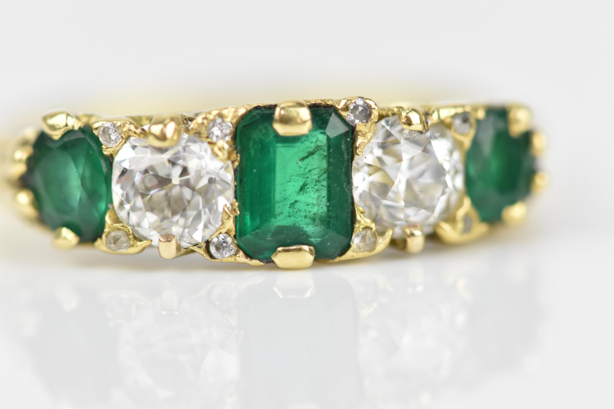 A yellow metal, diamond and emerald five stone ring, set with central octagon cut emerald flanked - Image 4 of 6