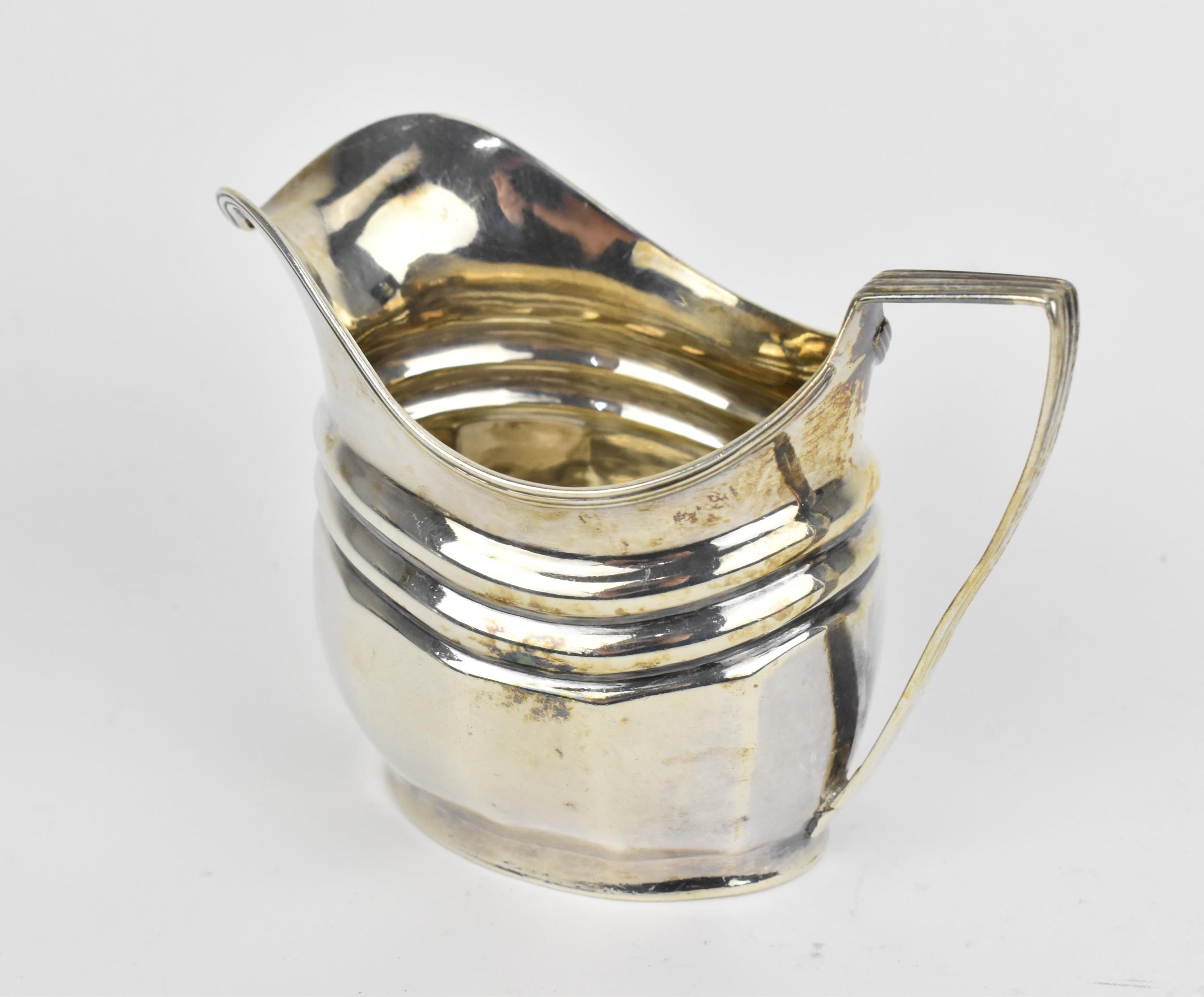 A George III silver milk jug, London 1804, with reeded handle and faceted body, 8.6 cm high, - Image 2 of 4