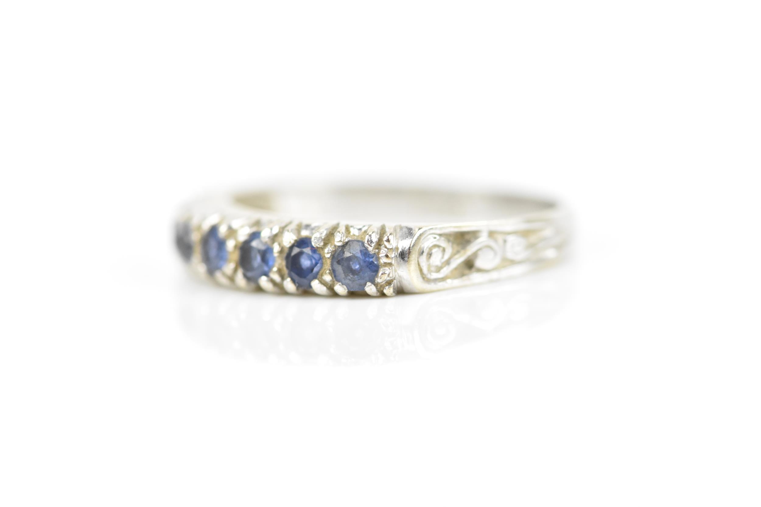 A 9ct white gold and blue sapphire half eternity ring, set with a row of seven same-sized pave-set - Image 2 of 7