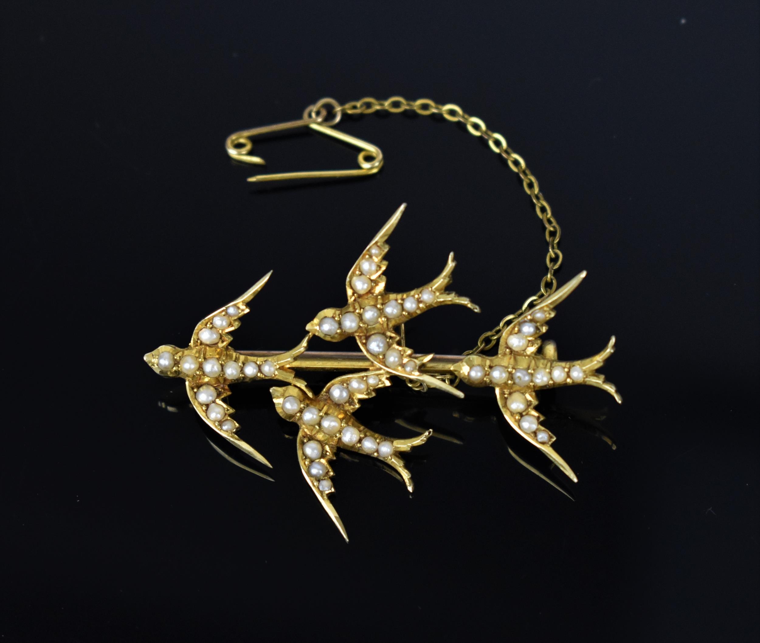 A 15ct yellow gold and seed pearl swallow brooch, probably Victorian, marked 15ct, with safety chain