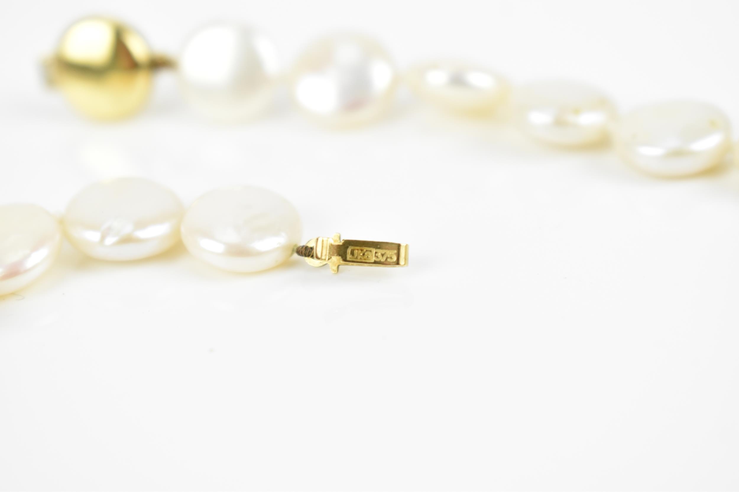 A single strand flat coin pearl necklace with 9ct yellow gold catch clasp, 45 cm long, the catch - Image 5 of 5