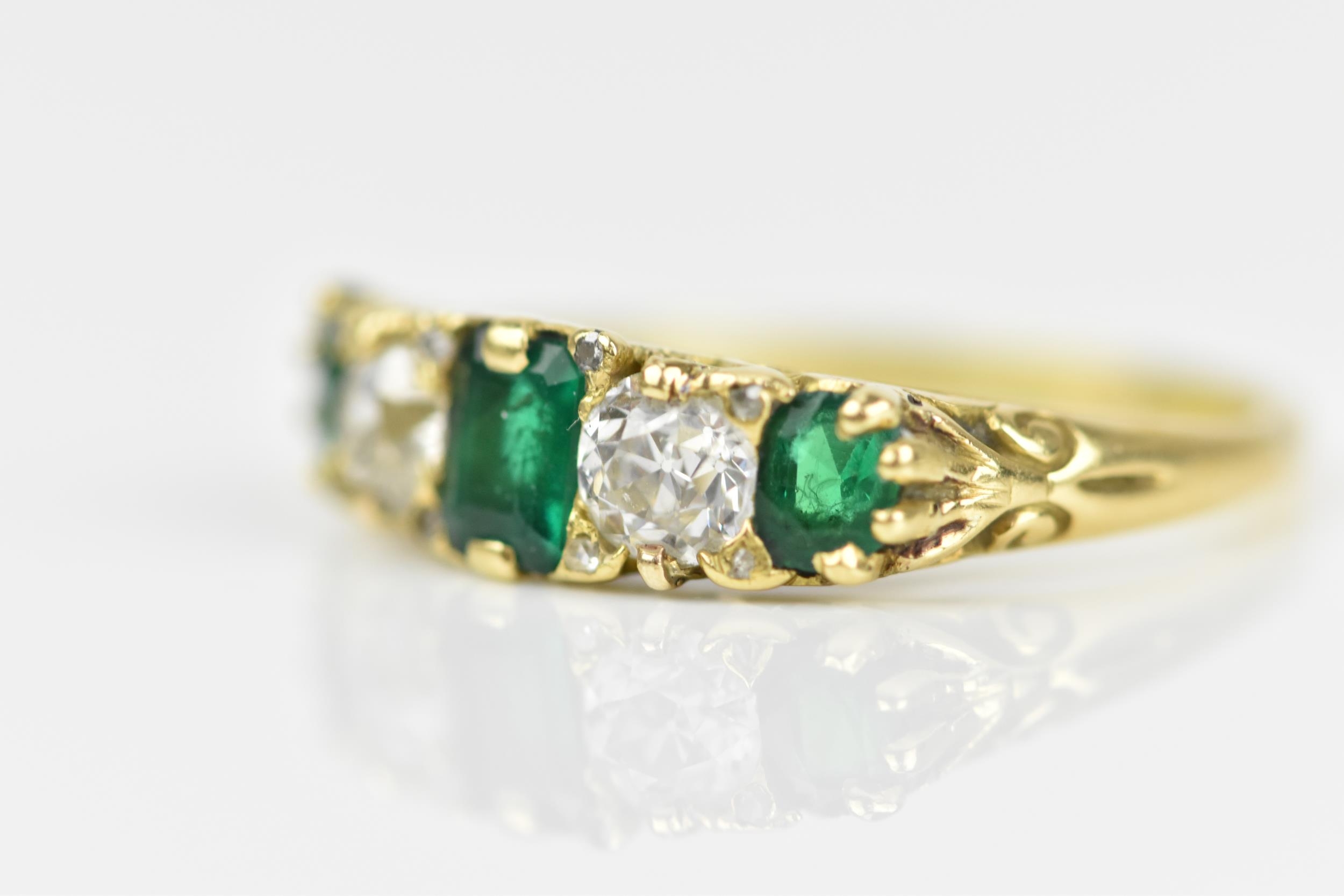 A yellow metal, diamond and emerald five stone ring, set with central octagon cut emerald flanked - Image 2 of 6