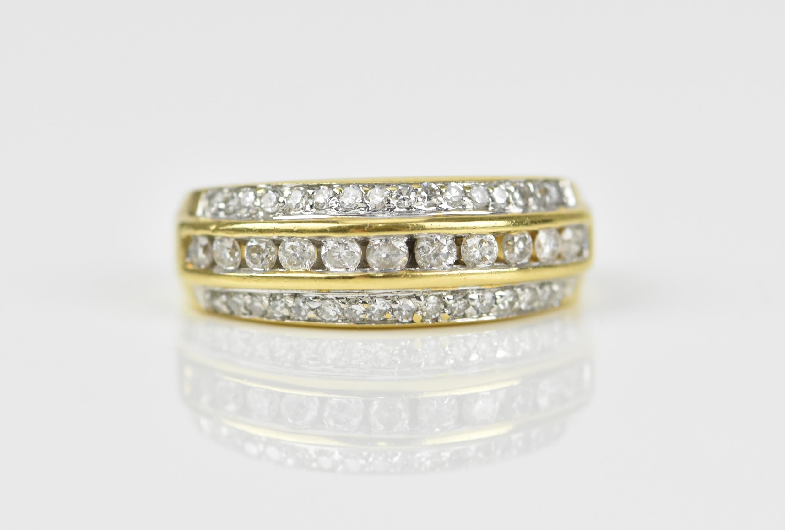 An 18ct yellow gold and diamond three row ring, set with a central row of brilliant cut channel