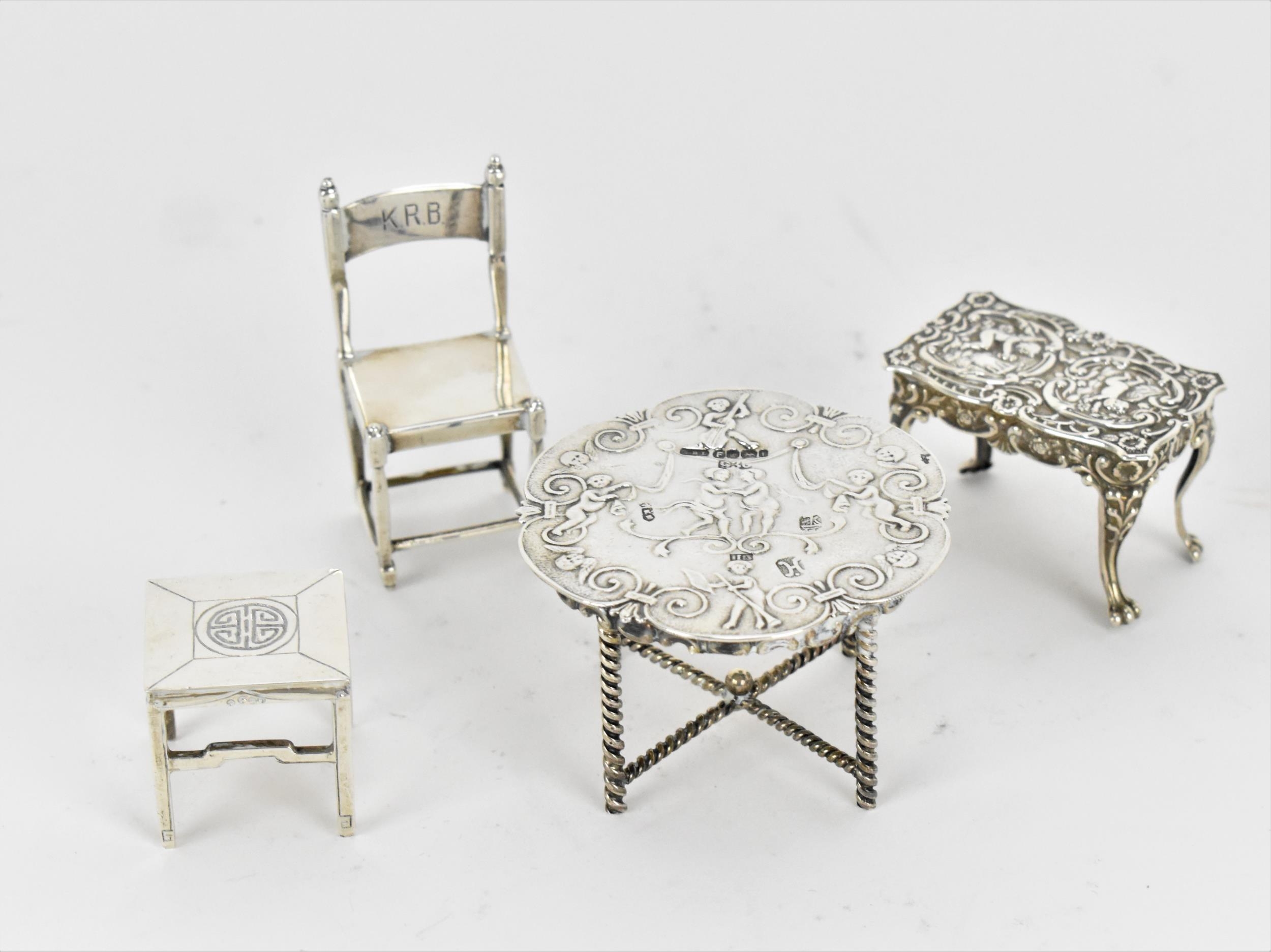 A small collection of silver and white metal miniature doll house furniture, to include a silver