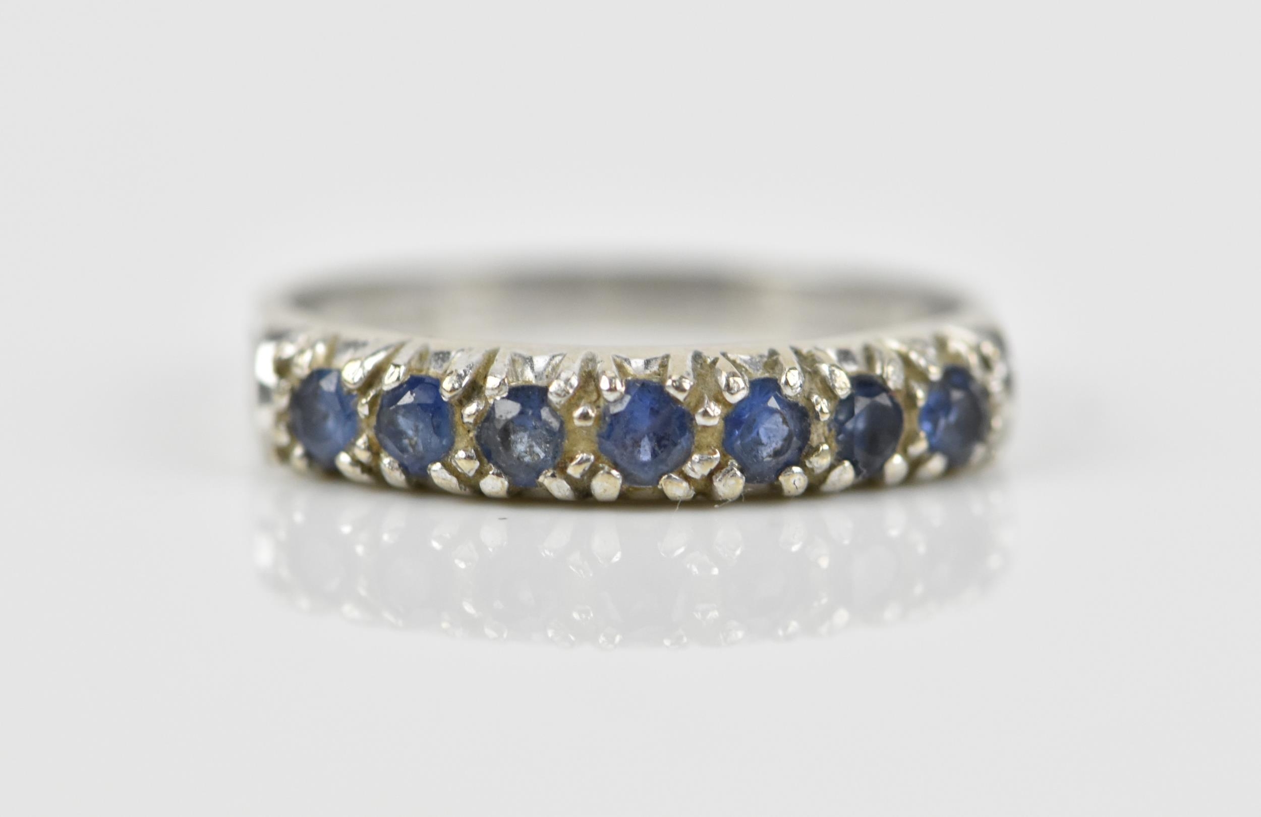 A 9ct white gold and blue sapphire half eternity ring, set with a row of seven same-sized pave-set - Image 7 of 7