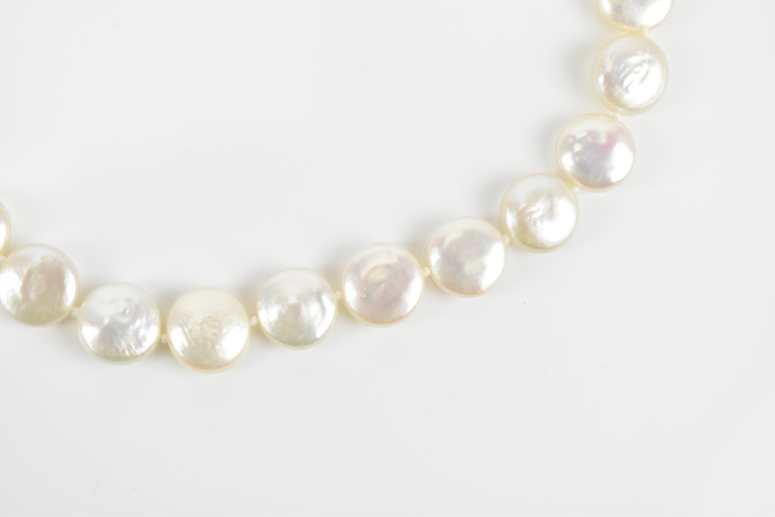 A single strand flat coin pearl necklace with 9ct yellow gold catch clasp, 45 cm long, the catch - Image 4 of 5